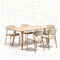 Dining table with stone top and black wooden legs paired with four woven chairs